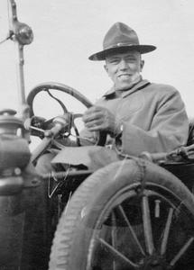 Man in uniform at wheel of car