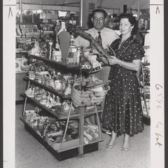 Two salespeople examine souvenirs in a drugstore display