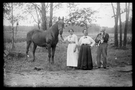 Horse with dog and group of people