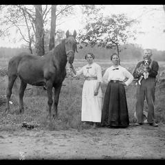 Horse with dog and group of people