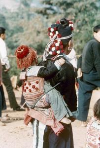 A White Hmong mother carries her child in Houa Khong Province