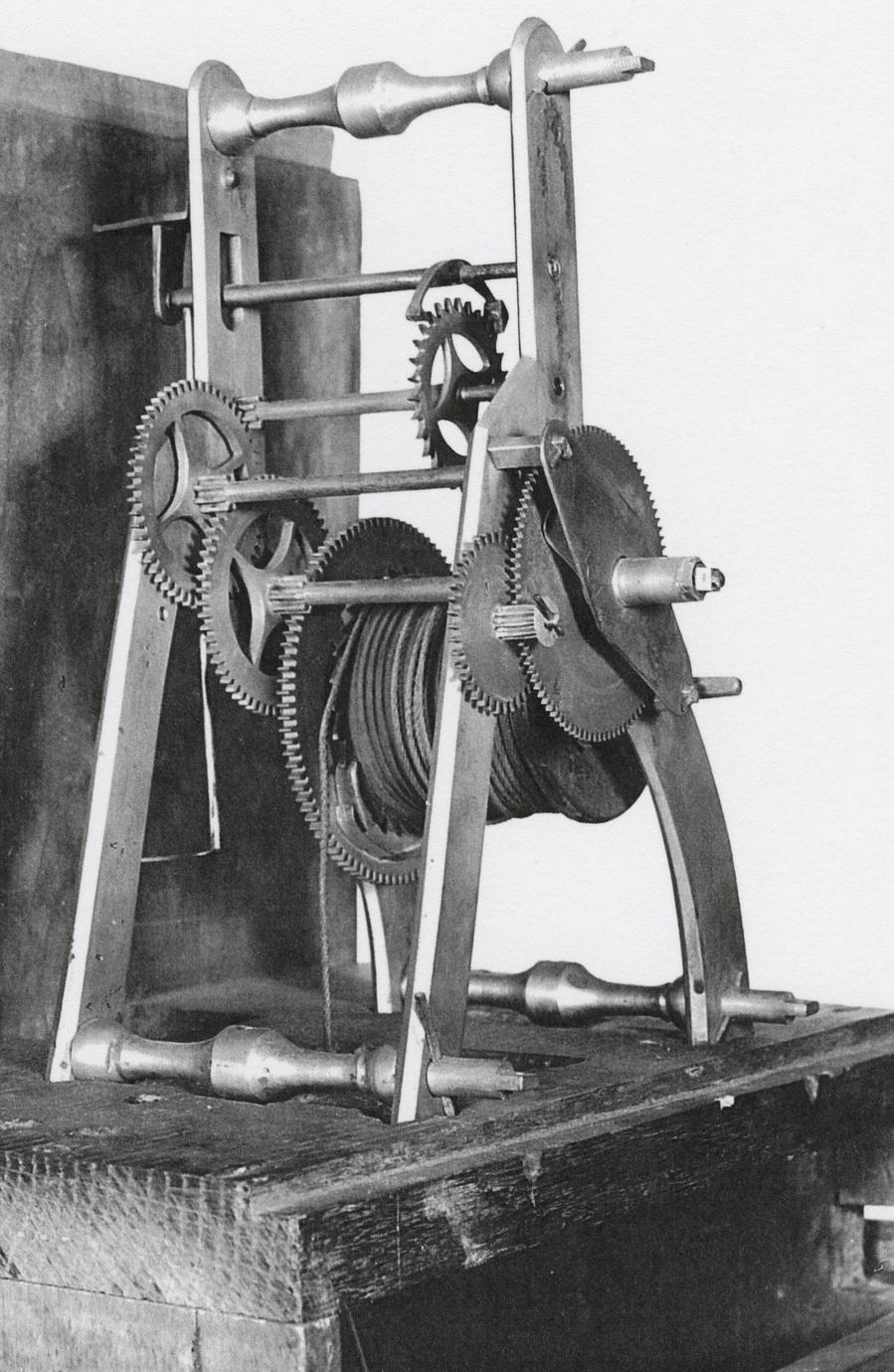 Black and white photograph of a tall-case clock gear system.