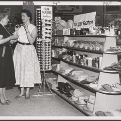 Two women examine items in the vacation goods aisle of a drugstore