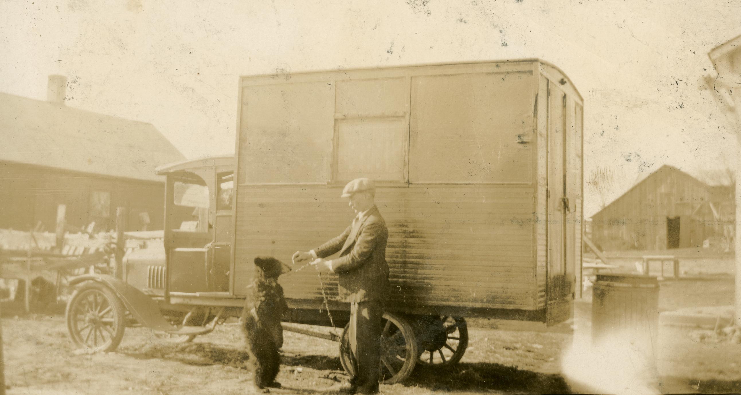 Frank Hall with bear in front of circus truck