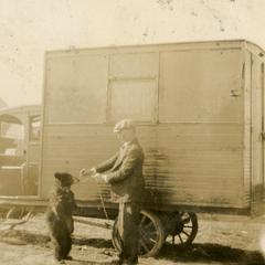 Frank Hall with bear in front of circus truck