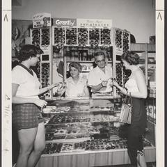 Two young women select sunglasses from a drugstore display