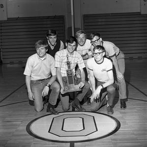 Men's basketball team holding trophy