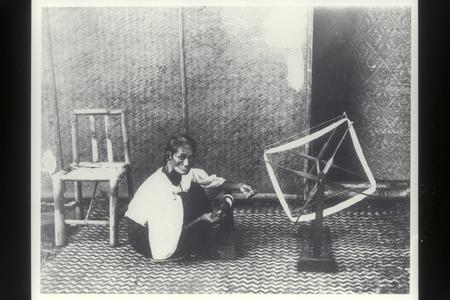 Woman spinning thread with a wooden spinning wheel, 1900s