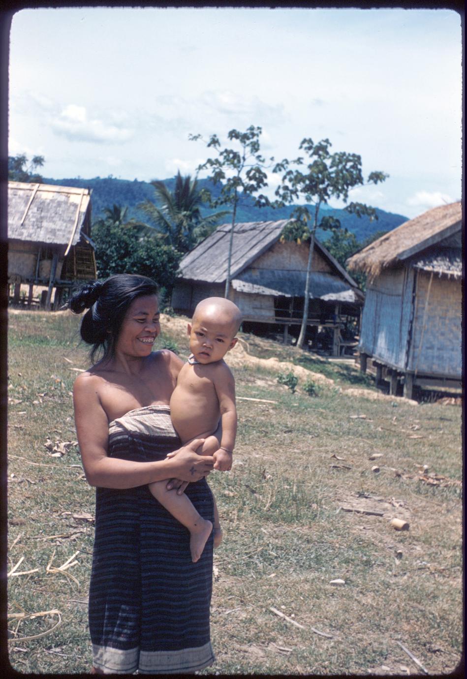 Lao mother and child near Kasy, houses in background