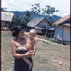 Lao mother and child near Kasy, houses in background