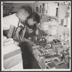 Three young boys examine items in a drugstore soap display