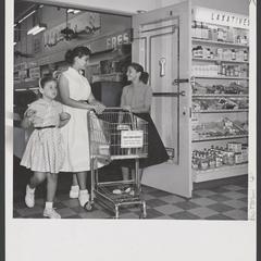 Three young women enter a drugstore with a shopping cart