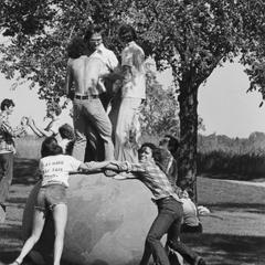 Students standing on Earth Ball on university grounds