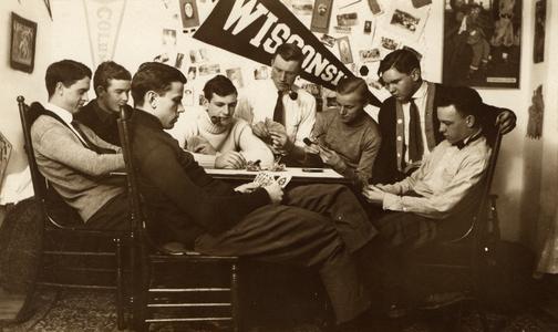 Men playing cards around table in house