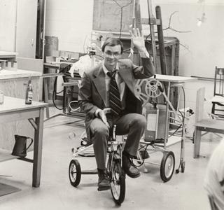 Sociology professor Miles Meidam on a tricycle