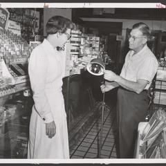 A pharmacist discusses the features of a heat lamp with a saleswoman