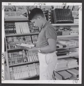 A young boy views books in a drugstore display