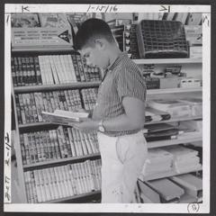 A young boy views books in a drugstore display