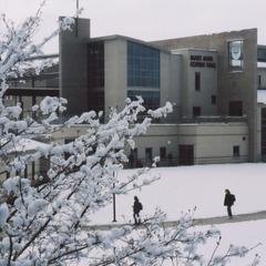 Mary Ann Cofrin Hall exterior in winter with people walking in the foreground