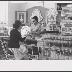 A saleswoman assists a shopper at the cosmetics counter
