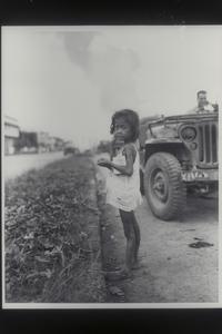 Starved child waiting for rations after bombing, Manila, 1945