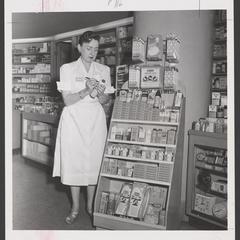 A woman holds a bottle of foot powder in a drugstore