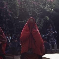 Masquerade performer in red cloth at the Nike Centre for Art and Culture