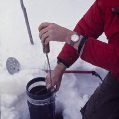 Taking a water sample from under lake ice