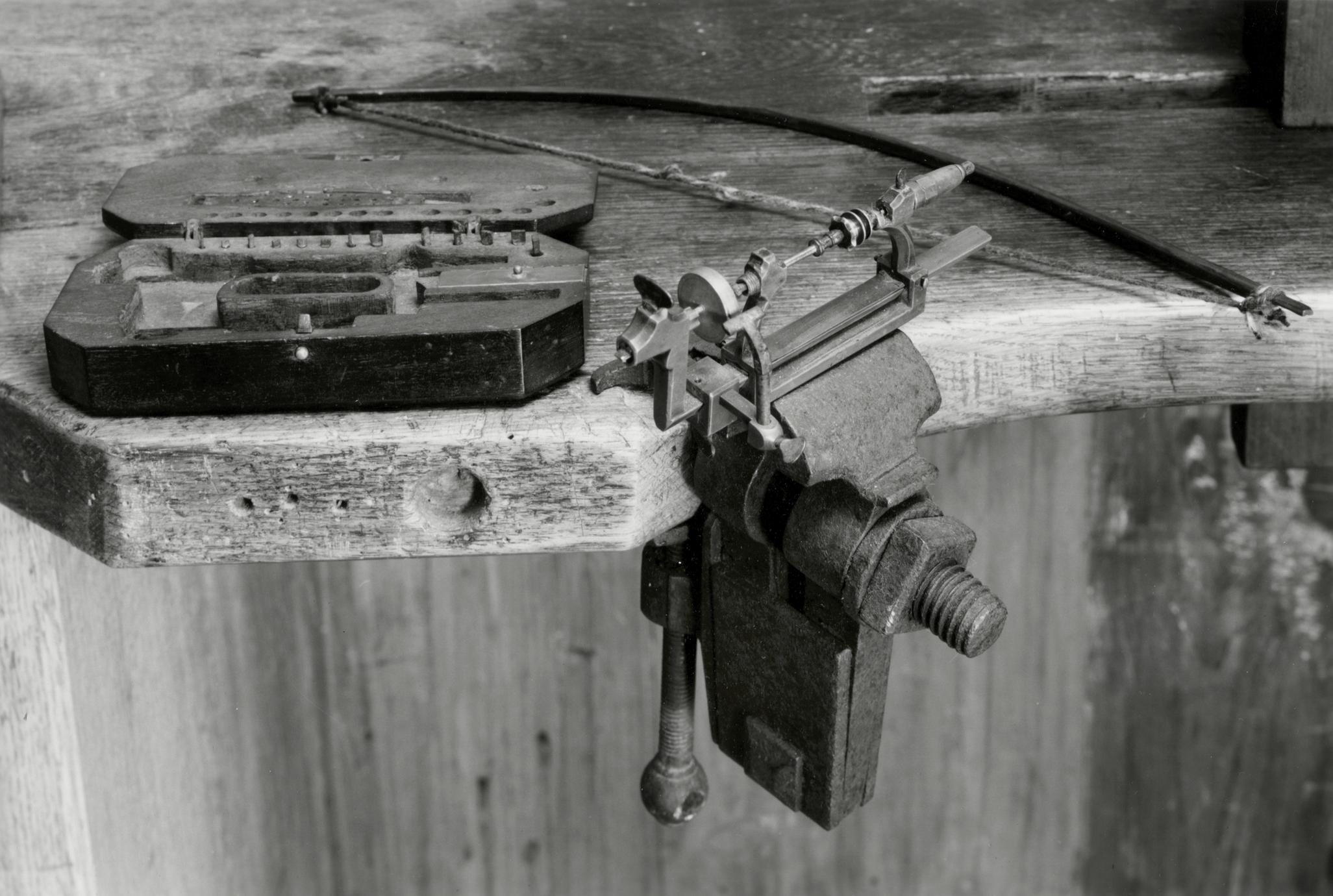 Black and white photograph of a watchmaker's bow, turn and case.