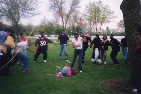 Woman breaks pinata during the 2002 multicultural picnic