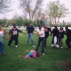 Woman breaks pinata during the 2002 multicultural picnic