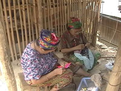 Two elderly women making paj ntaub