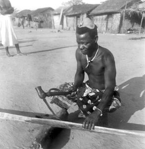Kuba-Ngongo Man Carving a Paddle