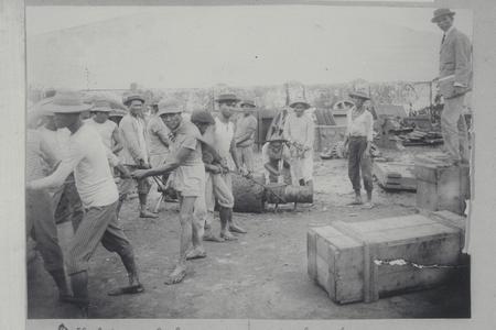Filipino laborers working as the boss looks on