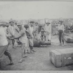 Filipino laborers working as the boss looks on
