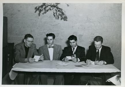 Sigma Tau Gamma officers, sitting at a table looking at Christmas cards
