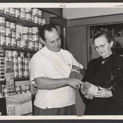 A pharmacist helps a customer select paint