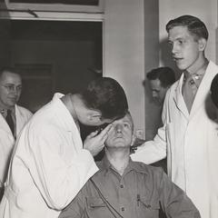 Medical students examine man's eye