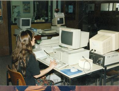 Female student works on desktop computer in library