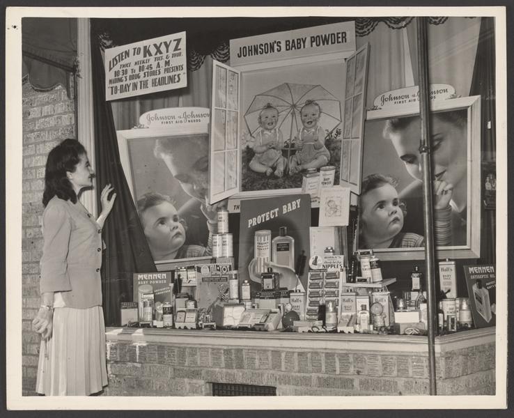 A woman and young boy look at fishing gear in a drugstore display - UWDC -  UW-Madison Libraries