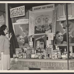 A woman views a pharmacy window display