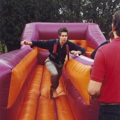 Music professor Peter Gibeau running through inflatable obstacle course
