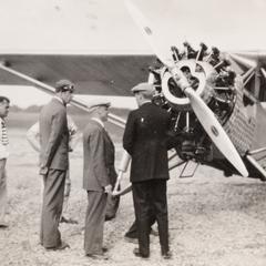 Unidentified group of men looking at Lindbergh's plane