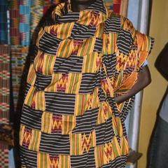 Man poses in traditional African fabrics.