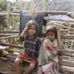 Two Nyaheun children sit outside their family garden in Attapu Province