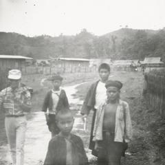 Four Akha youth walk through Muang Meung in Houa Khong Province