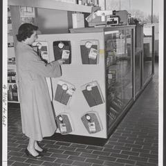 A woman examines bathroom scales in a drugstore display