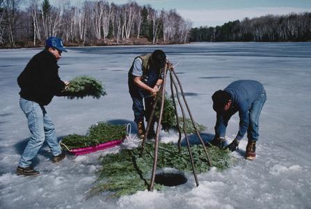 John Snow sets ice-fishing tipi poles in place on Sugarbush Lake