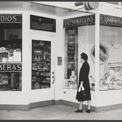 A woman approaches the entrance to a drugstore