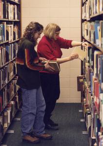 Foreign language professor Mary Pable helping student find books in library